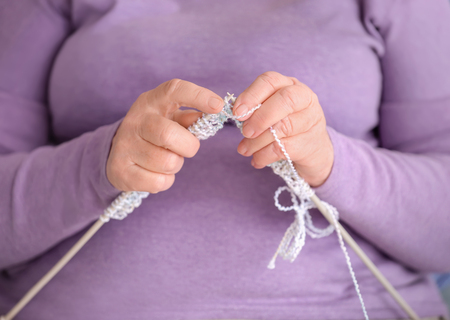 Senior woman knitting sweater, closeup