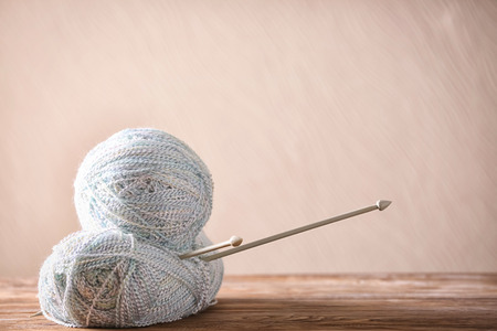 Knitting yarn with needles on wooden table