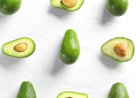 Flat lay composition with ripe avocados on white wooden backgroundの写真素材