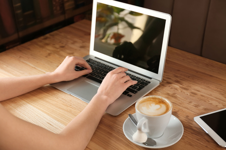 Young freelancer with laptop working in cafeの写真素材