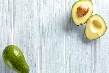Ripe avocados on light wooden background