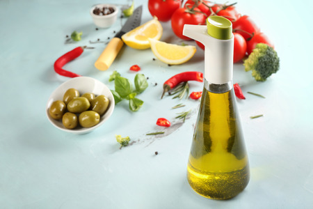 Bottle with fresh olive oil on tableの写真素材