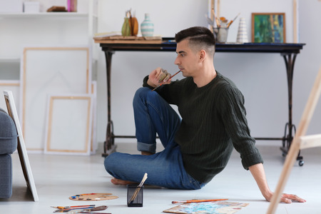 Male artist waiting for inspiration in workshopの写真素材