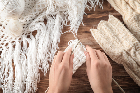 Woman knitting at wooden tableの写真素材