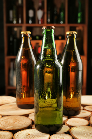 Fresh beer in glass bottles on wooden tableの写真素材