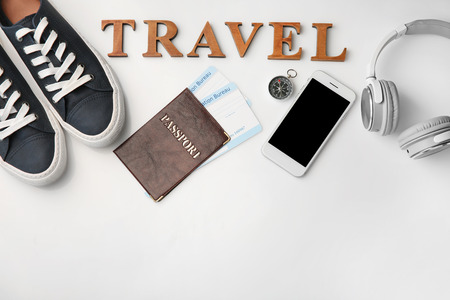 Composition with passport, immigration bureau cards, smartphone and word "Travel" on white backgroundの写真素材