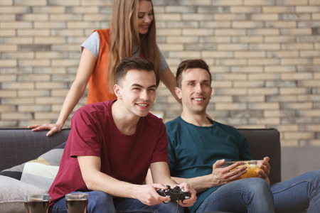 Young people playing video games at home