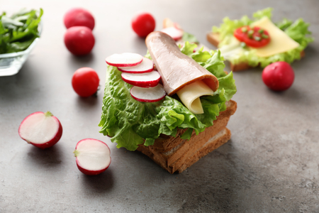 Toasted bread with ham and vegetables on tableの写真素材