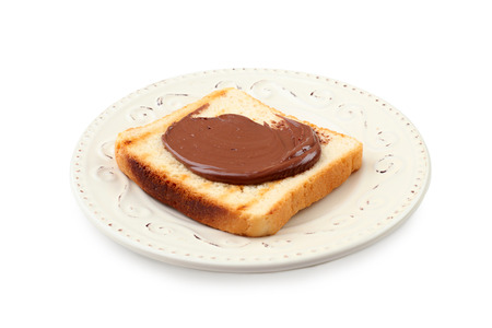 Toasted bread with chocolate paste on plate, isolated on whiteの写真素材