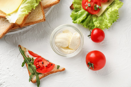 Toasted bread with cheese and tomatoes on tableの写真素材