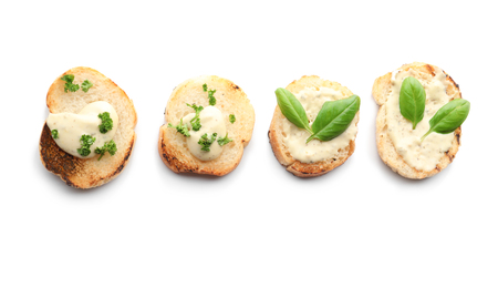 Toasted bread with cream cheese and herbs on white backgroundの写真素材
