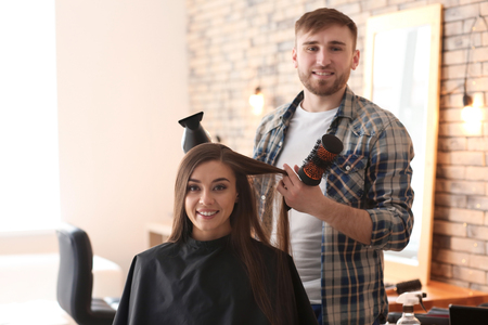 Professional hairdresser working with client in salonの写真素材