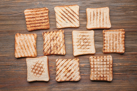 Tasty toasted bread on wooden background