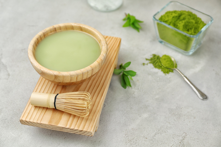 Bowl of matcha tea with whisk on wooden standの写真素材