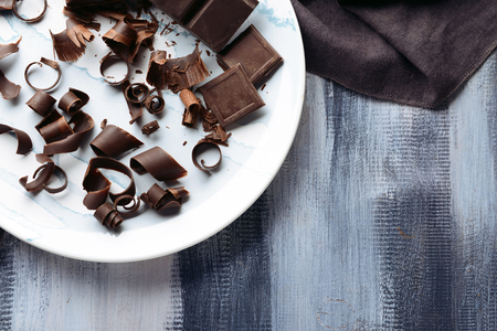 Plate with delicious chocolate curls on tableの写真素材