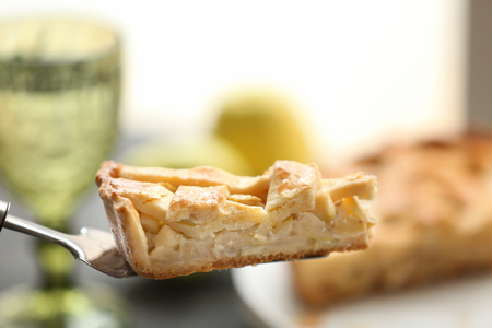 Spatula with piece of tasty apple pie on blurred backgroundの写真素材