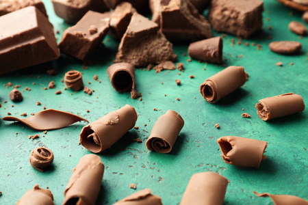 Delicious chocolate curls on color background