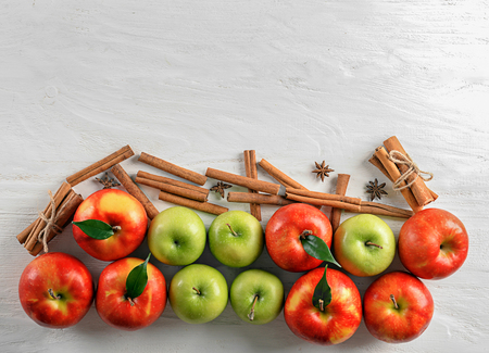 Composition with fresh apples and cinnamon sticks on white wooden backgroundの写真素材
