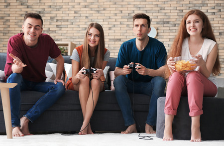 Young people playing video games at homeの写真素材