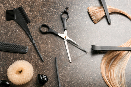 Professional hairdresser's set with strand of blonde hair on grey backgroundの写真素材