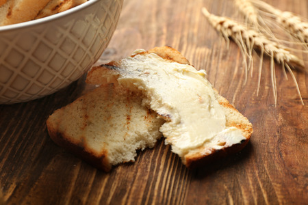 Toasted bread with butter on wooden table