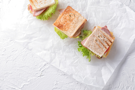 Tasty sandwiches with lettuce on white tableの写真素材