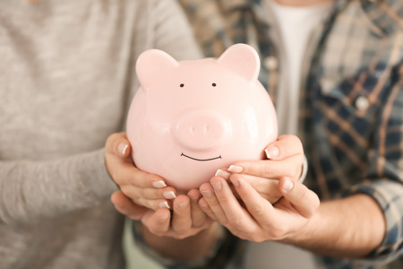 Couple holding piggy bank, closeup. Money savings conceptの写真素材