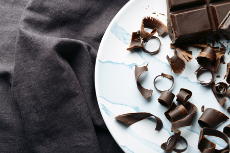 Plate with delicious chocolate curls on tableの写真素材