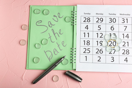 Calendar with text "Save the Date" on color backgroundの写真素材