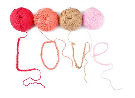 Word LOVE made of threads and colorful knitting yarn on white backgroundの写真素材