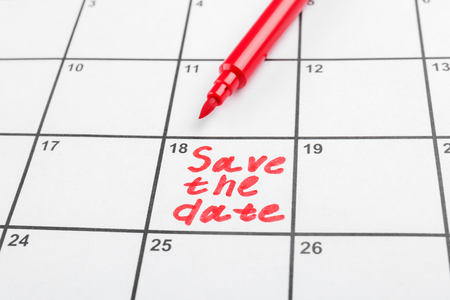 Red marker and phrase "Save the Date" written on calendar, closeupの写真素材