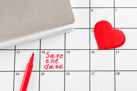 Heart, notebook and phrase "Save the Date" written on calendarの写真素材