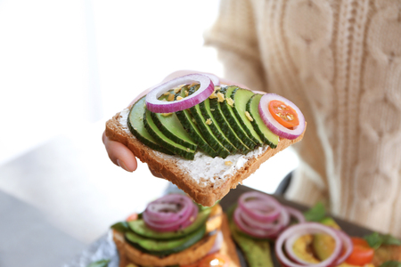 Woman holding delicious toast with avocado, closeupの写真素材