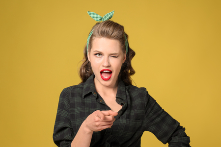 Beautiful young woman with pointing finger on color backgroundの写真素材