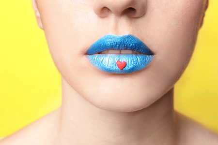 Beautiful young woman with creative makeup on color background, closeupの写真素材
