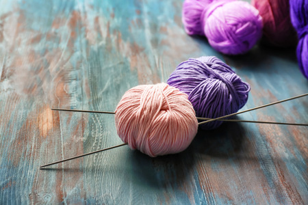 Knitting yarn with needles on wooden tableの写真素材