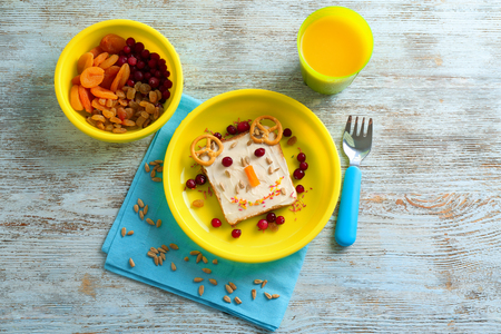 Creative sweet toast for child with cup of juice on wooden tableの写真素材