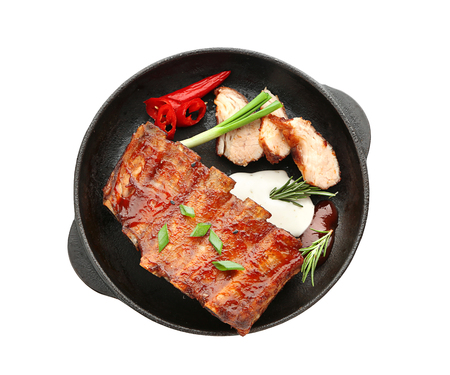 Frying pan with delicious grilled ribs on white backgroundの写真素材
