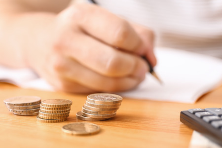 Young man counting money at table, closeupの写真素材