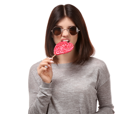 Young woman with lollipop on white backgroundの写真素材