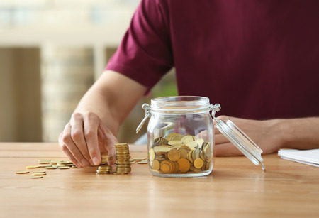 Man stacking coins on table