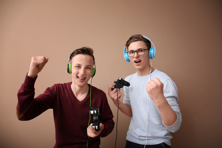 Teenagers with gamepads on color backgroundの写真素材