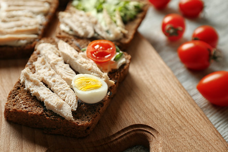 Delicious toast with meat and egg on board, closeupの写真素材