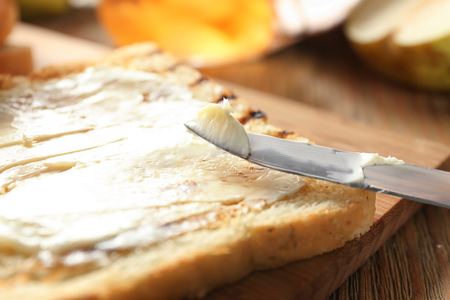 Tasty toast with butter on wooden board, closeupの写真素材