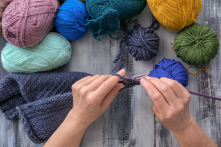 Mature woman knitting warm sweater at table, closeupの写真素材