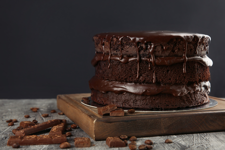 Wooden board with delicious chocolate cake on tableの写真素材