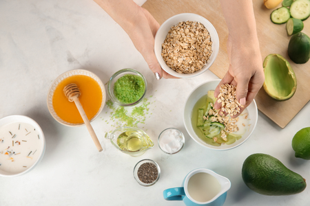 Woman making nourishing mask with avocadoの写真素材