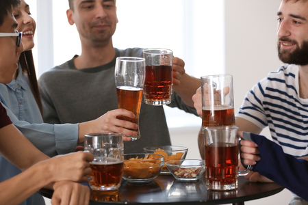 Group of friends clinking glasses with beer in barの写真素材