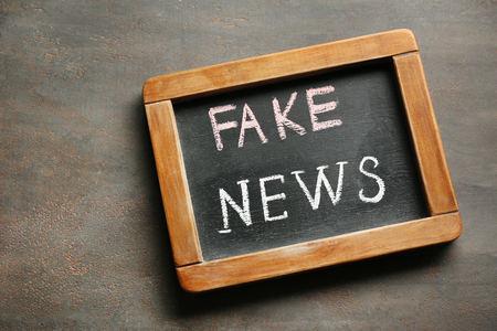 Chalkboard with text FAKE NEWS on grey backgroundの写真素材