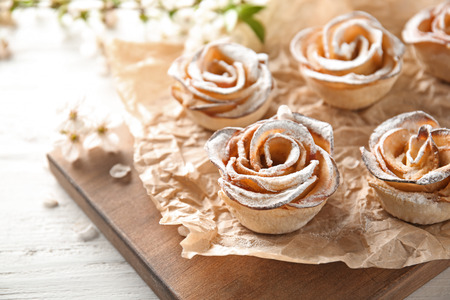 Tasty apple roses from puff pastry on wooden boardの写真素材